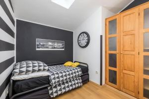a room with a bed and a clock on the wall at Holiday Home Doda in Fažana - 100 m from the Sea in Fažana