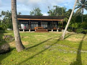 a house with two palm trees in front of it at Villa Pandan Simeulue in Salul