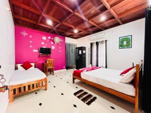 Munroe IslandMundro Garden Homestay的一间卧室设有两张床和粉红色的墙壁