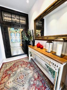 ベレス・マラガにあるPUERTA de la AXARQUIA HOTEL BOUTIQUEの鏡と赤りんごのテーブルが付いた部屋