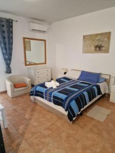 a bedroom with a bed and a mirror and a chair at villa martha in Yaiza