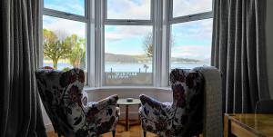 two chairs sitting in front of a window at Boat House Super Suites in Rothesay