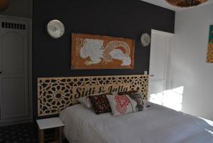 a bedroom with a bed with a black wall at Maison Sidi et Lalla in Essaouira