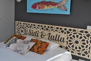 a bed with a head board with a fish on it at Maison Sidi et Lalla in Essaouira
