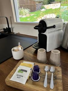 a kitchen counter with a coffee maker and spoons at Maison au bord de l'eau Les Roches in Rochefort-sur-Nenon