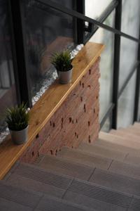 Una pared de ladrillo con tres macetas. en Vista apartment2, en Choszczówka