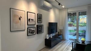 a living room with a tv and pictures on the wall at LemonNing Condo in Budapest