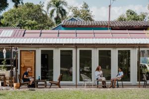 eine Gruppe von Menschen, die auf der Terrasse eines Hauses sitzen in der Unterkunft The Yard Hostel Chiang Mai in Chiang Mai