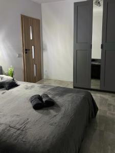 un par de zapatillas sentadas en una cama en un dormitorio en Vista apartment2, en Choszczówka 12 fotos más