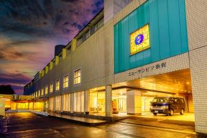 een gebouw met een busje ernaast geparkeerd bij New Sunpia Tsuruga in Tsuruga