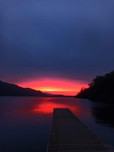 a dock on a lake with a sunset at Lake & bike Mergozzo in Mergozzo