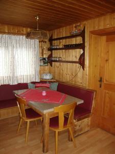 a dining room with a table and chairs and wine bottles at Turner-Hütte in Heiligenblut +8 photos