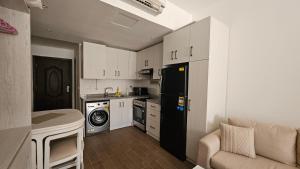Il comprend une cuisine équipée d'un réfrigérateur noir et d'un lave-linge. dans l'établissement Fully equipped studio Sahl Hasheesh, à Hurghada