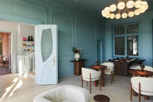 a blue room with tables and chairs and a door at stilwerk Strandhotel Blankenese in Hamburg