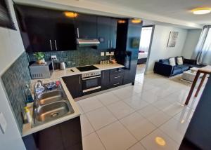 a kitchen with a sink and a stove top oven at Cozy Retreat in Windhoek in Windhoek
