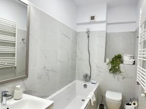 a bathroom with a sink and a tub and a toilet at Luxury COZY Suites & Studios at Unirea Towers in Iaşi +24 photos