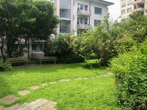 a park with a bench and a building at Bright studio in the city center - Greenyard 1 in Zürich