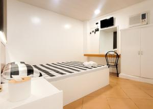 a white room with a bed and a chair at Green Meadows Hotel & Restaurant in San Nicolas