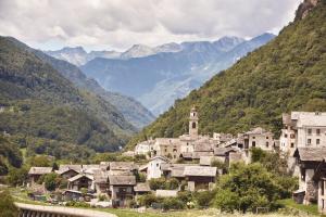 a village in a valley with mountains in the background at Das Pöstli – Ristorante Garni Post in Castasegna