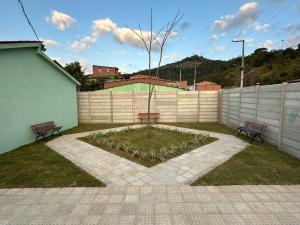 a tree in the middle of a courtyard with two benches at Portal Araticum Flats in Bonito