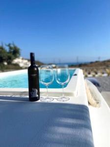 a bottle of wine and two glasses sitting on a table at Villa ilios, Stelida Naxos, by NaxosVibe in Naxos Chora