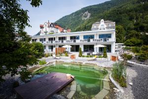 um hotel com piscina em frente a um edifício em Carlton-Europe Vintage Adults Hotel em Interlaken