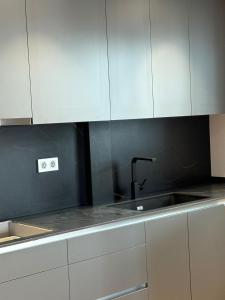 a kitchen with white cabinets and a sink at chalet barcelona in Barcelona