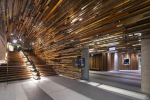 a lobby with wooden stairs in a building at Nishi-Execs Couples and family retreat in Canberra