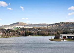 a view of a large lake with mountains in the background at Nishi-Execs Couples and family retreat in Canberra