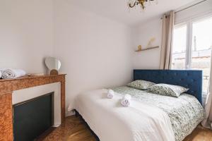 une chambre avec un lit bleu et une cheminée dans l'établissement Le Royal - Cathédral - Center, à Reims