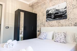 a bedroom with a white bed with a car on the wall at Affittacamere 911 in Paratico