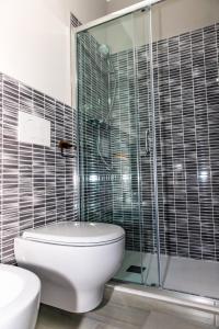 a bathroom with a toilet and a glass shower at Affittacamere 911 in Paratico