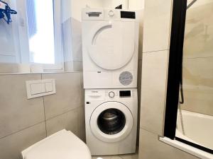a washer and dryer in a small bathroom at Vibehome Düsseldorf - Stadtmitte in Düsseldorf +76 photos