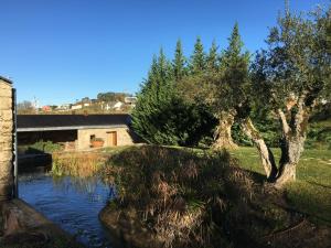 ポンバルにあるAcquavillaの木々と建物のある川の景色