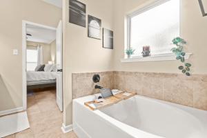 a bathroom with a bath tub and a bedroom at 3br Retreat Plush Beds High-speed Wi-fi in Lake Charles +30 photos