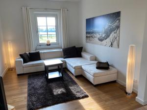 a living room with a white couch and a table at Ferienhäuser Weitblick in Gilten