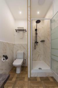 a bathroom with a toilet and a glass shower at Design Apartments with Panoramic View in Kyiv +19 photos