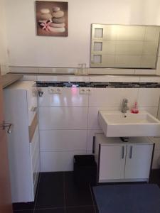 a white bathroom with a sink and a mirror at Apartment Renate Strohhöfer in Hirschaid