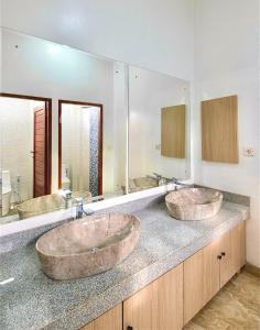 two sinks in a bathroom with two mirrors at Sleep Slept Dormitory in Canggu