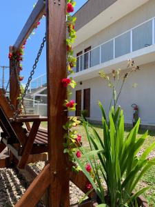 eine Schaukel vor einem Gebäude mit Blumen in der Unterkunft Pousada Recanto Som do Mar in Caraguatatuba