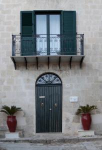a building with a green door and a balcony at Sorge Palace in Mussomeli