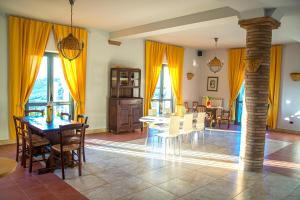 a dining room with yellow curtains and a table and chairs at La Tana B&B in Flumeri