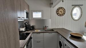 eine Küche mit einer Theke und einer Uhr an der Wand in der Unterkunft L escale du Bassin 800 m de la plage 3 pers in Andernos-les-Bains + 18 Fotos