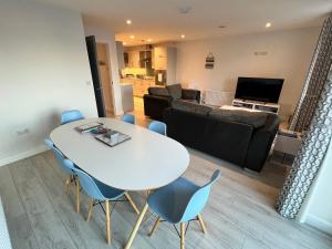 a living room with a white table and blue chairs at Royal Atlantic View Apartment in Portrush