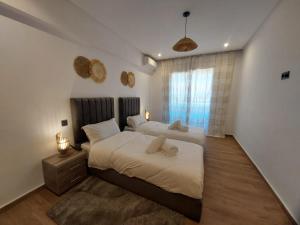 um quarto com duas camas e uma janela em Palm Appart em Marraquexe mais 25 fotografias