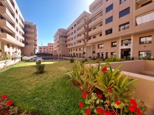 uma vista de um complexo de apartamentos com flores vermelhas em Palm Appart em Marraquexe