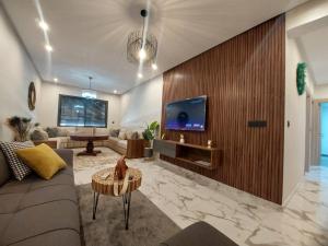 uma sala de estar com um sofá e uma TV na parede em Palm Appart em Marraquexe