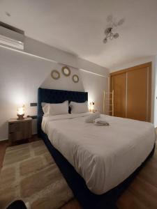 um quarto com uma cama grande com cabeceira azul em Palm Appart em Marraquexe