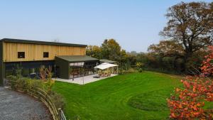 una casa con un patio verde y un edificio en Dragons Barn with Hot Tub, en Great Malvern