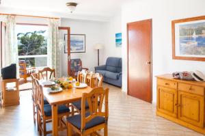 a dining room and living room with a table and chairs at Apartamento Playa Dor 17 in Cala d´Or